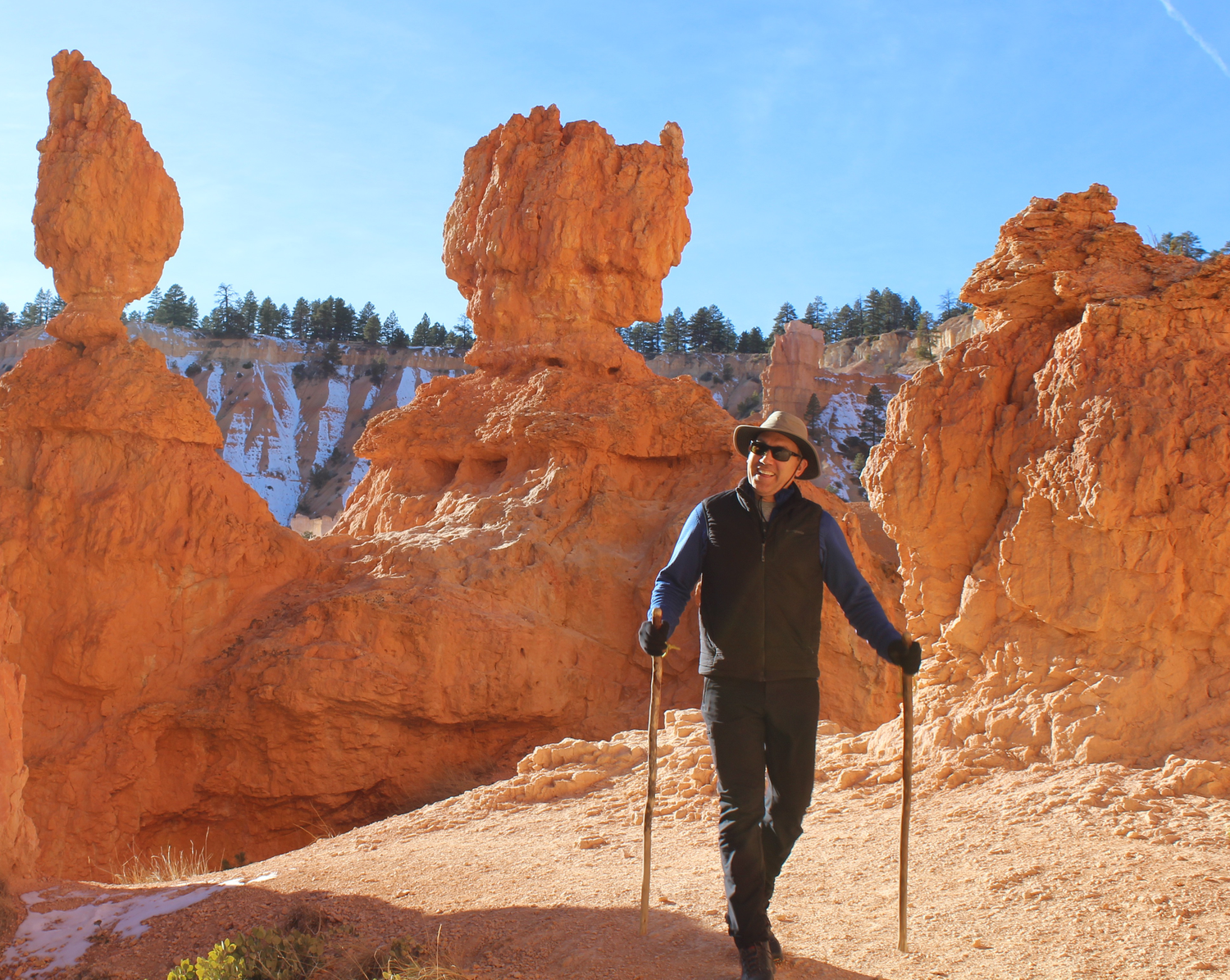 Philip Benson hiking among orange rock formations with trekking poles